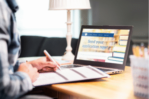 Student completing an online admission application on a laptop for 10th class distance education in India through ODLC.