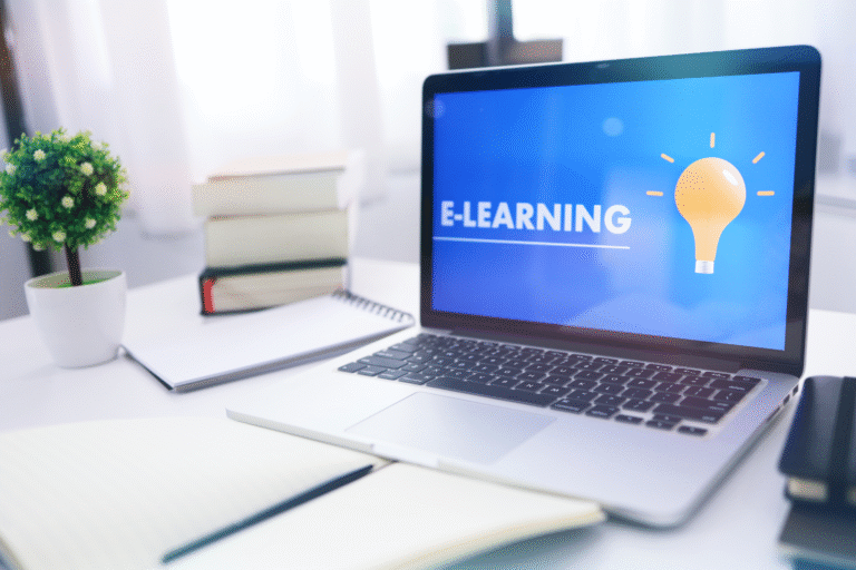 "Laptop displaying an e-learning platform with books and a notebook on a study desk, representing digital learning skills, online education, and flexible learning."
